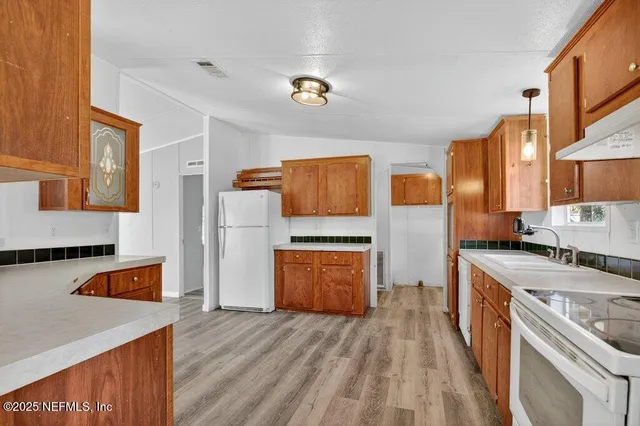 a kitchen with stainless steel appliances granite countertop a stove a sink and a refrigerator
