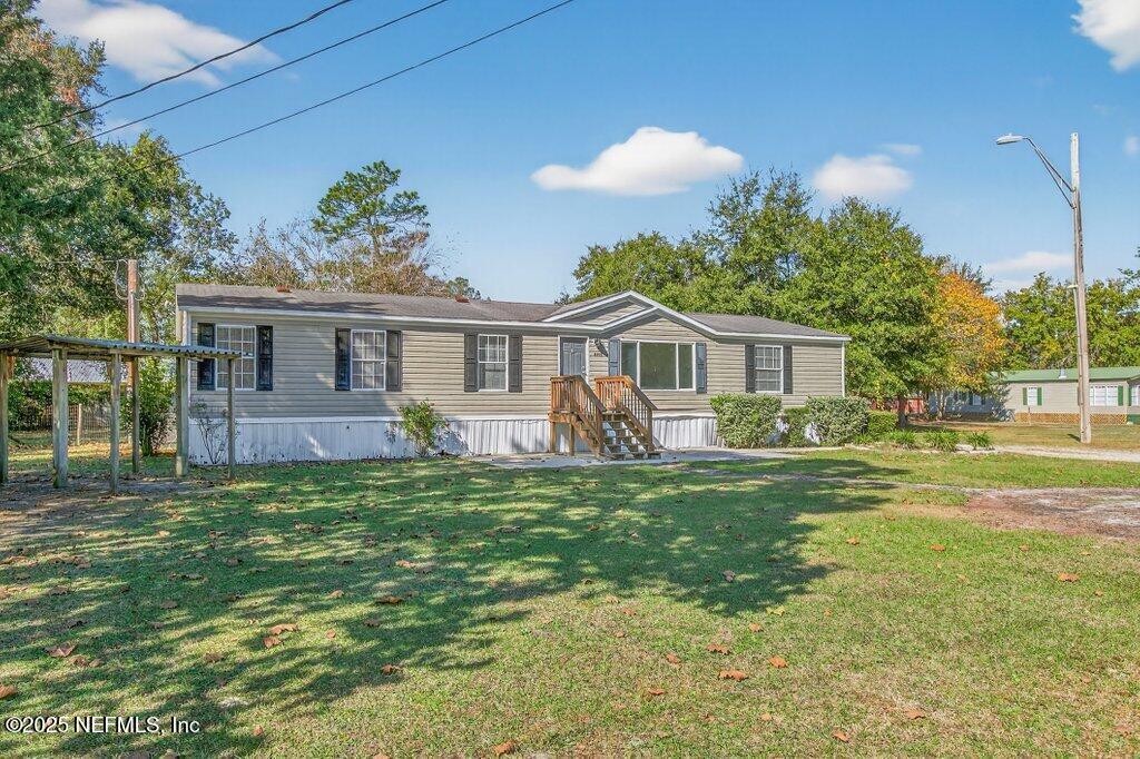 9899 Barber Loop Macclenny, FL 32063 - Photo 2 of 43 a front view of a house with a garden