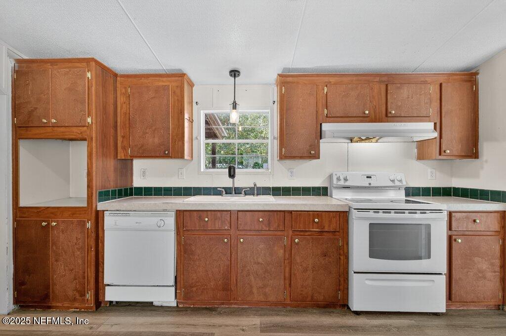 9899 Barber Loop Macclenny, FL 32063 - Photo 21 of 43 a kitchen with stainless steel appliances granite countertop a stove a sink and a refrigerator