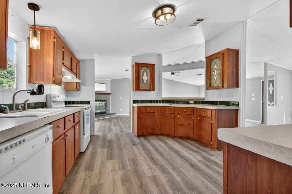 9899 Barber Loop Macclenny, FL 32063 - Photo 23 of 43 a kitchen with stainless steel appliances granite countertop wooden cabinets and sink