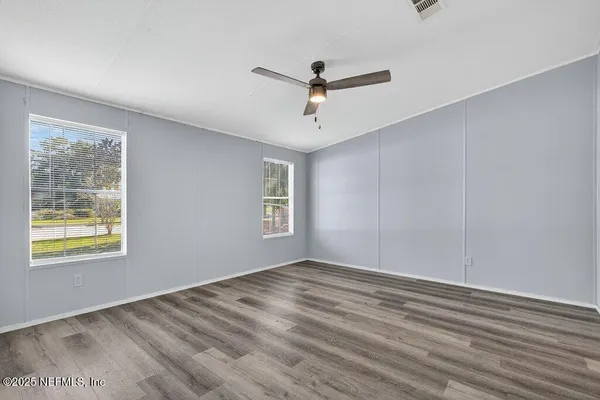 a view of empty room with wooden floor