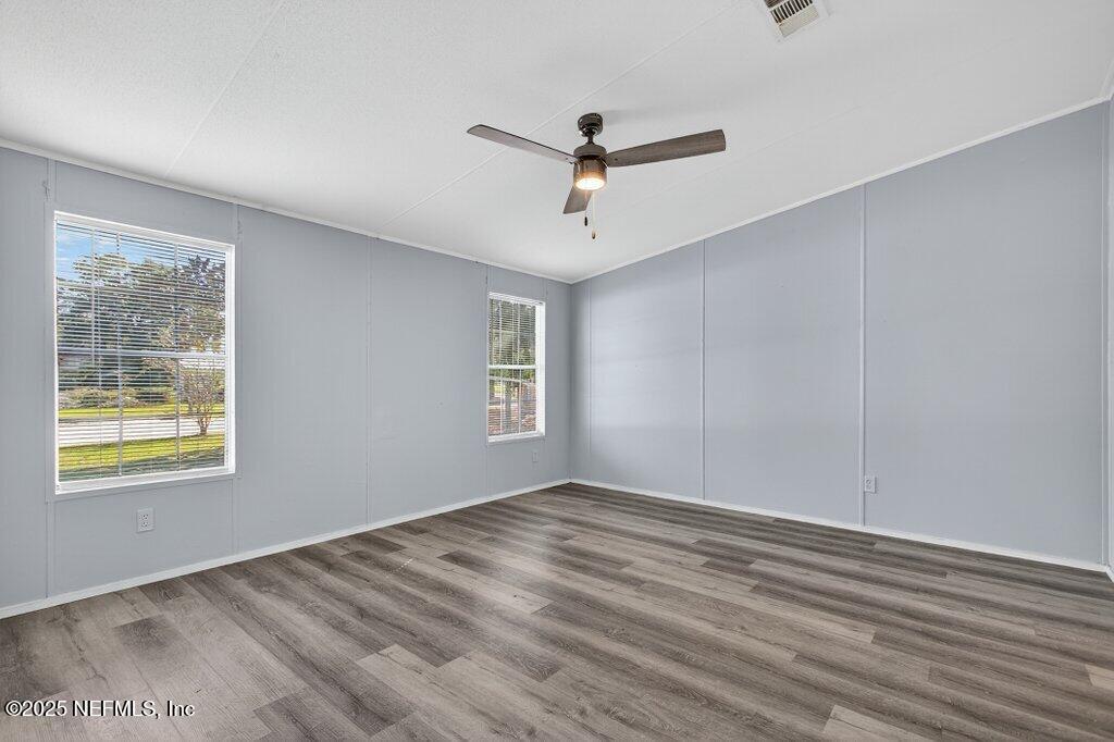 9899 Barber Loop Macclenny, FL 32063 - Photo 24 of 43 a view of an empty room with wooden floor and a window