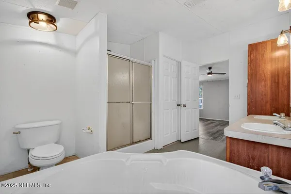 a view of a big room with wooden floor and windows