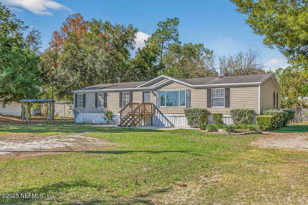 9899 Barber Loop Macclenny, FL 32063 - Photo 3 of 43 a front view of a house with a yard