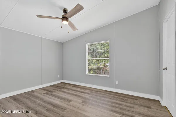 a view of an empty room with wooden floor