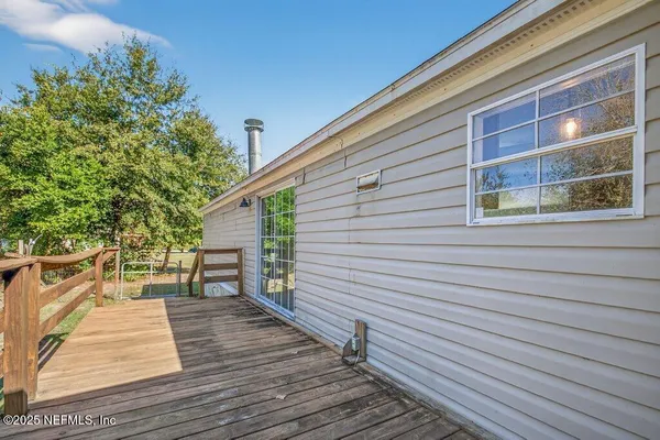 a view of a balcony with wooden floor and fence and a floor to ceiling window