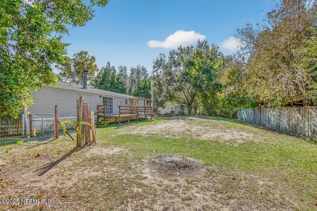 a view of backyard with a garden and deck