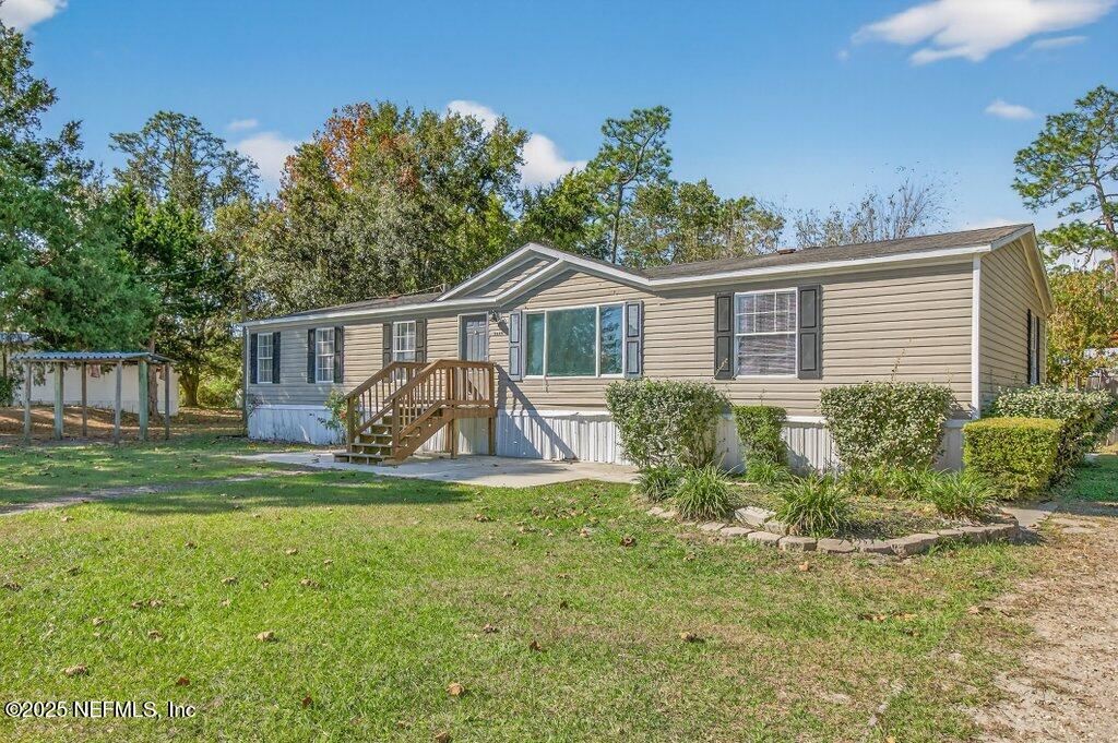 9899 Barber Loop Macclenny, FL 32063 - Photo 4 of 43 a view of a house with a yard and a garden