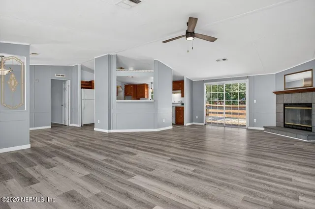 a view of empty room with wooden floor and fireplace