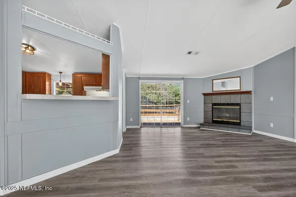 a view of a livingroom with wooden floor and a fireplace