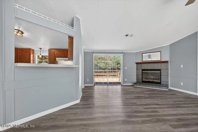 a view of a livingroom with wooden floor and a fireplace