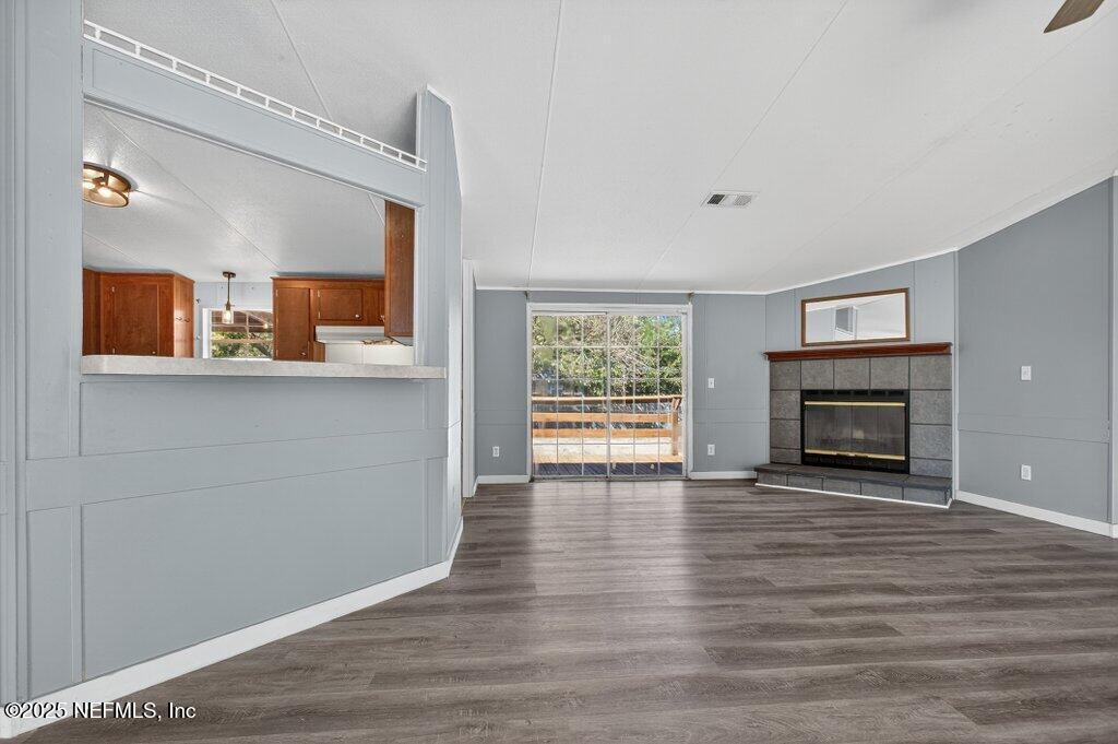 9899 Barber Loop Macclenny, FL 32063 - Photo 10 of 43 a view of a livingroom with wooden floor and a fireplace