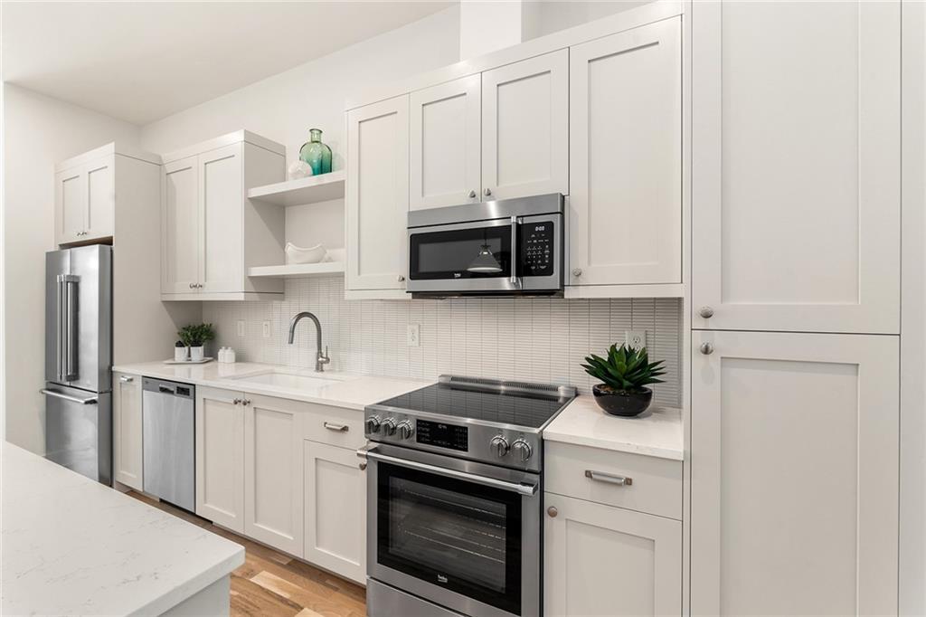 1237 Memorial Drive Southeast, Unit 403 Atlanta, GA 30316 - Photo 10 of 38 a kitchen with stainless steel appliances white cabinets and a stove a oven with white countertops