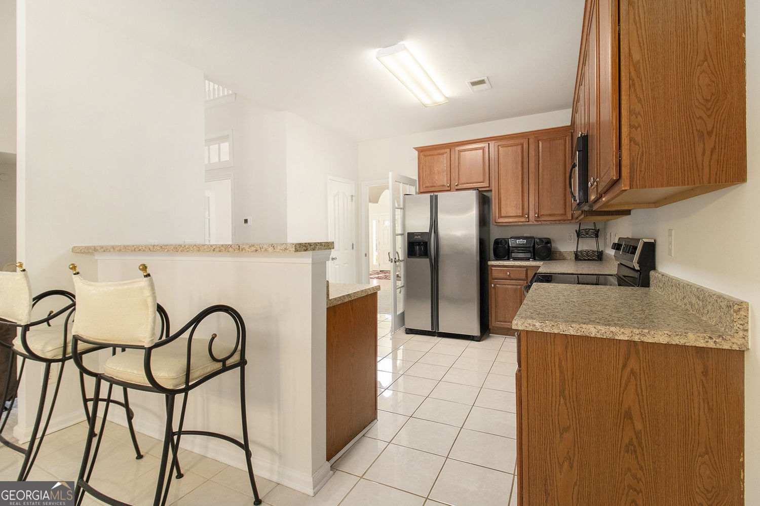 48 Garden View Terrace Newnan, GA 30263 - Photo 13 of 25 a kitchen with stainless steel appliances granite countertop a refrigerator a stove top oven and white cabinets