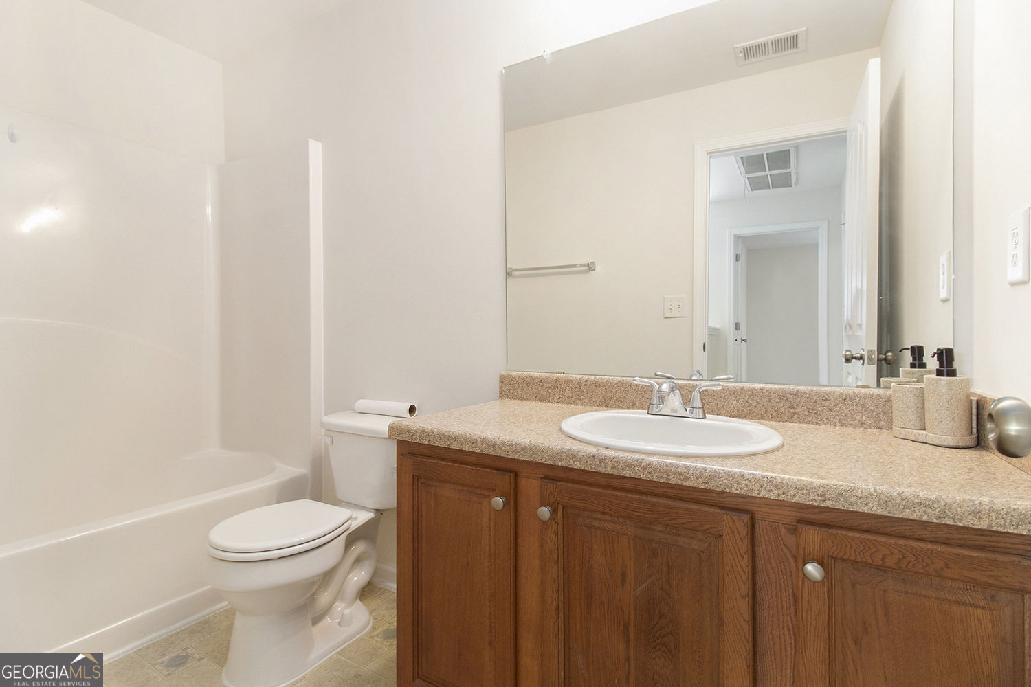 48 Garden View Terrace Newnan, GA 30263 - Photo 22 of 25 a bathroom with a granite countertop sink toilet a mirror and a bathtub