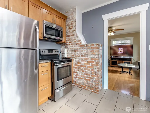 a kitchen with granite countertop a refrigerator and a stove top oven