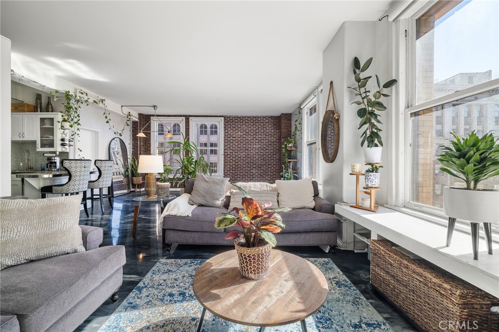 a living room with furniture potted plant and a large window