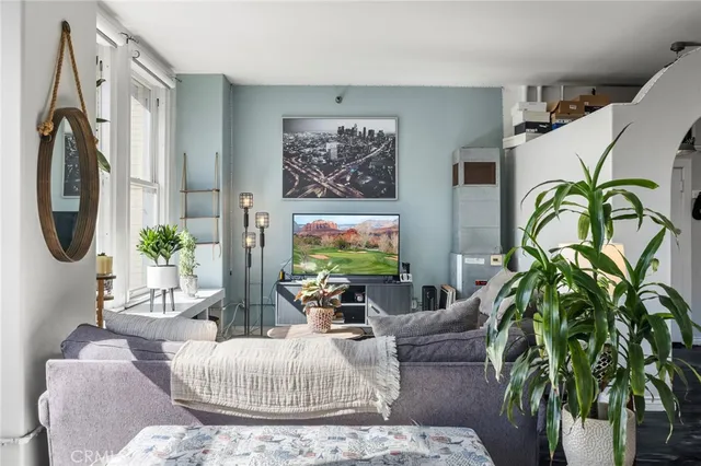 a living room with furniture a chandelier and a rug