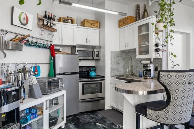 a kitchen with stainless steel appliances granite countertop a stove and cabinets