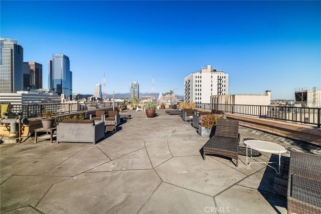 a roof deck with table and chairs a barbeque