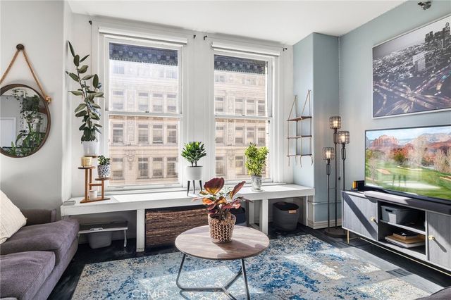 a living room with furniture a flat screen tv and a large window