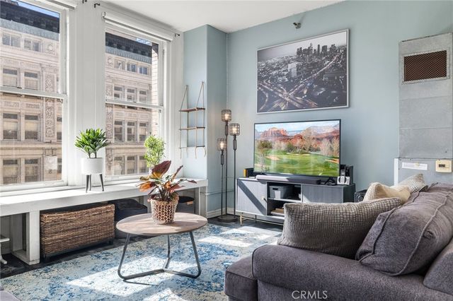 a living room with furniture a rug and a large window