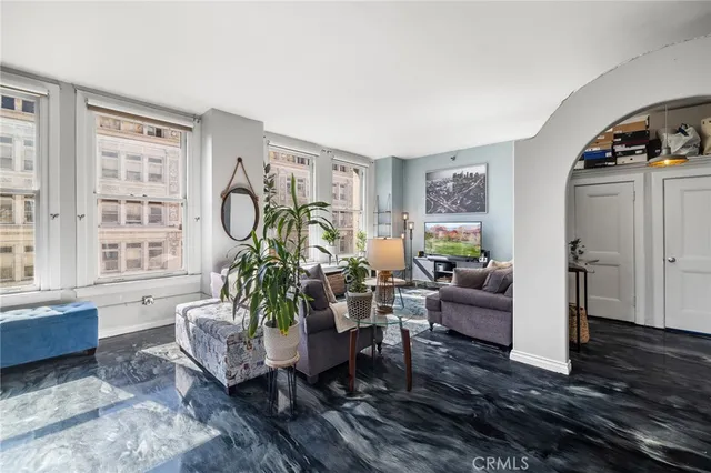 a living room with furniture large window and wooden floor