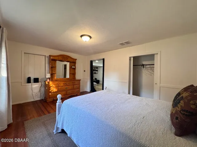 a bedroom with a bed and wooden floor