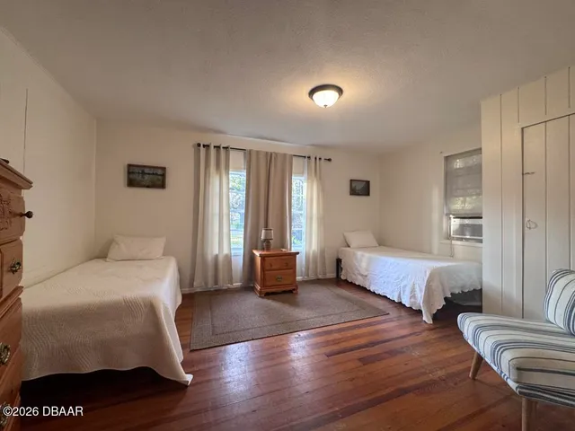 a bedroom with a bed and wooden floor