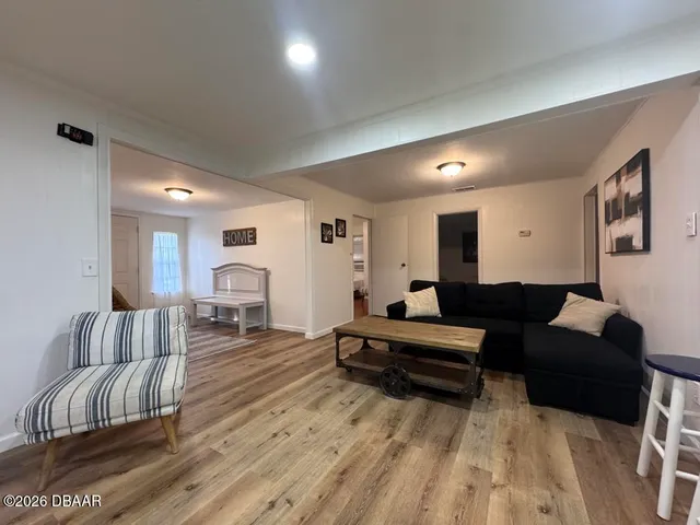 a living room with furniture and a wooden floor
