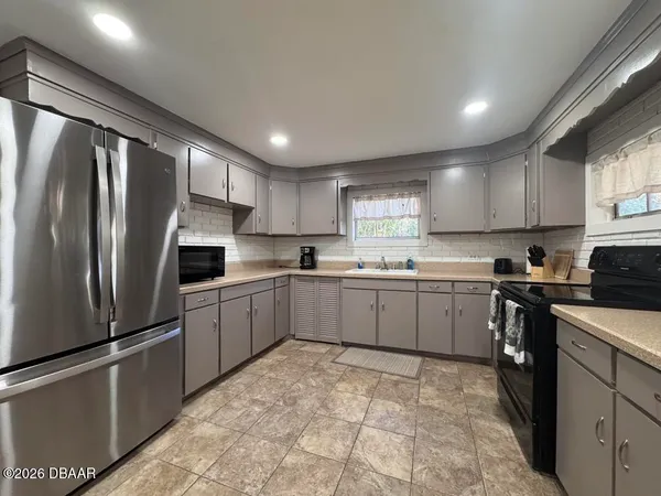 a kitchen with a refrigerator sink and cabinets