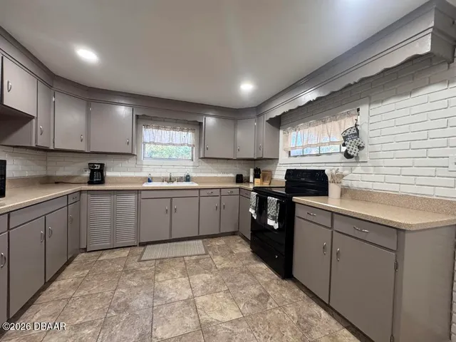 a kitchen with a sink window and cabinets