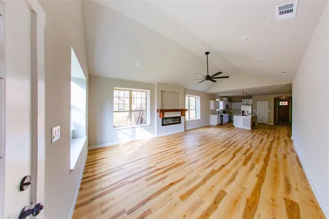 a large hall with wooden floor and a window
