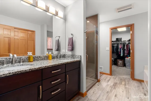 a bathroom with a granite countertop sink a mirror and a shower