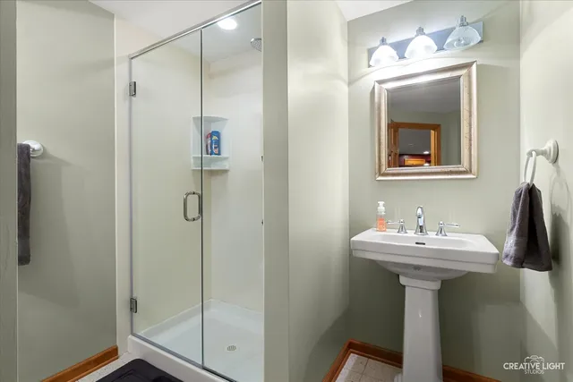 a bathroom with a sink mirror and shower