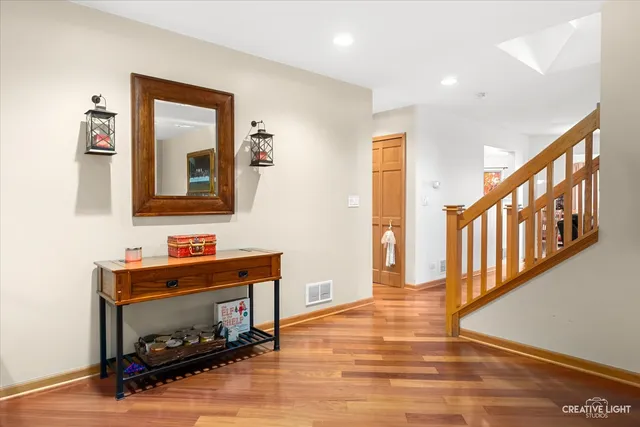 a hallway with wooden floor fireplace and windows