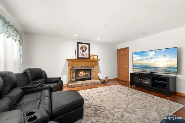 a living room with furniture a flat screen tv and a fireplace