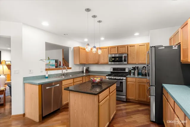 a kitchen with stainless steel appliances granite countertop a stove refrigerator sink and microwave
