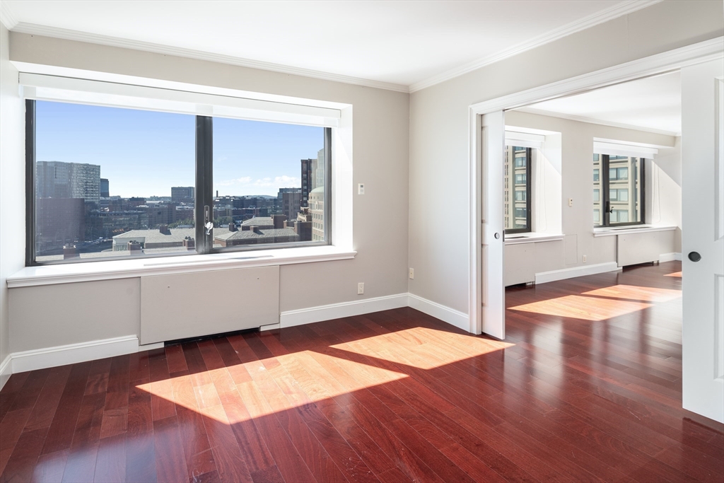 85 East India Row, Unit 15E Boston, MA 02110 - Photo 13 of 20 an empty room with wooden floor and windows