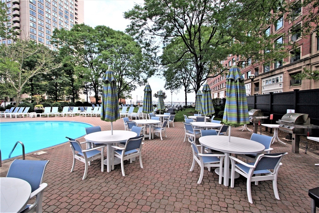 85 East India Row, Unit 15E Boston, MA 02110 - Photo 18 of 20 a view of a patio with a dining table and chairs with a garden