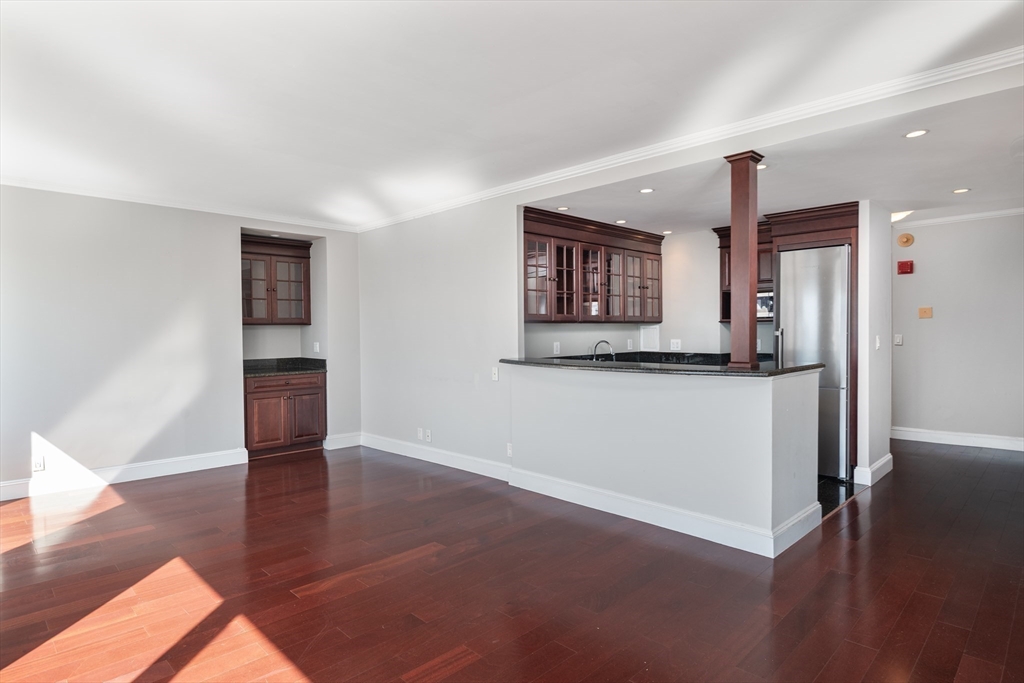 85 East India Row, Unit 15E Boston, MA 02110 - Photo 7 of 20 a view of a big room with wooden floor and a kitchen