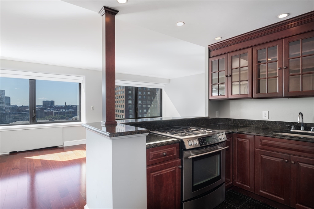 85 East India Row, Unit 15E Boston, MA 02110 - Photo 8 of 20 a kitchen with stainless steel appliances granite countertop a stove and a sink