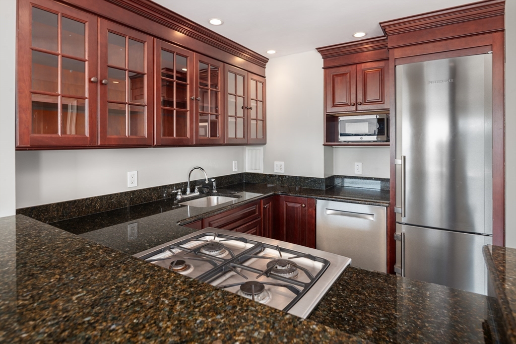 85 East India Row, Unit 15E Boston, MA 02110 - Photo 9 of 20 a kitchen with stainless steel appliances granite countertop a refrigerator and a sink