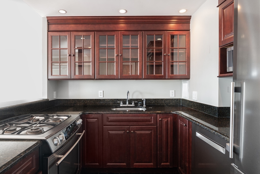 85 East India Row, Unit 15E Boston, MA 02110 - Photo 10 of 20 a kitchen with a stove and a sink