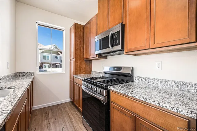 a kitchen with stainless steel appliances granite countertop a stove a microwave and a sink