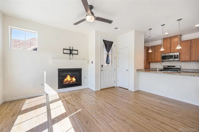 a view of a kitchen an empty room and fire place