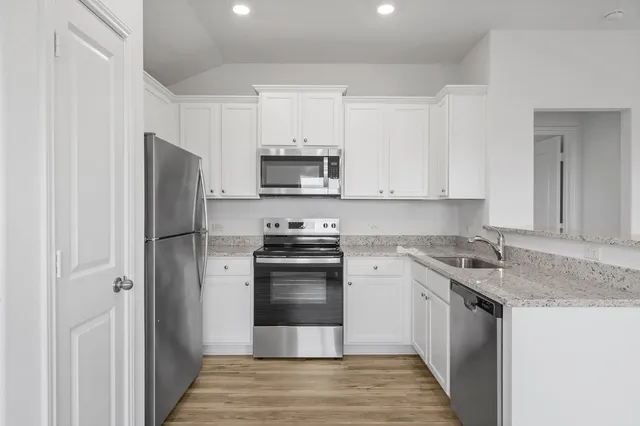 a kitchen with stainless steel appliances granite countertop a stove a refrigerator and a sink