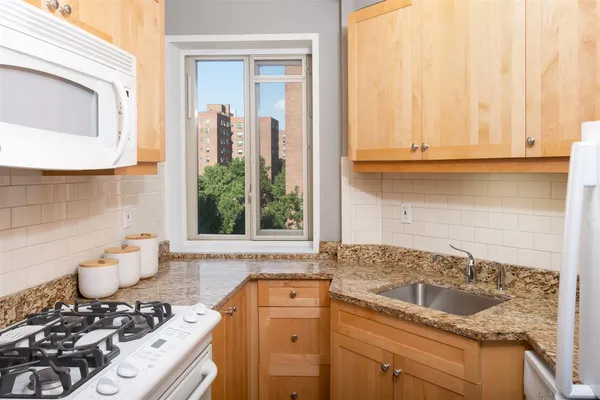 a bathroom with a granite countertop sink and a window