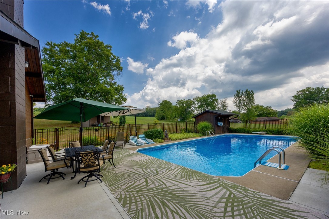 55901 Deep Run Road Martins Ferry, OH 43935 - Photo 7 of 50 View of swimming pool featuring a patio, a fenced backyard, an outbuilding, a storage unit, and outdoor dining space