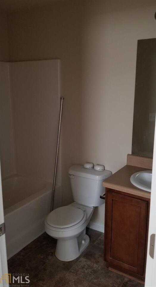 2441 Capella Circle Southwest Atlanta, GA 30331 - Photo 9 of 12 a white toilet sitting next to a bathroom sink and vanity